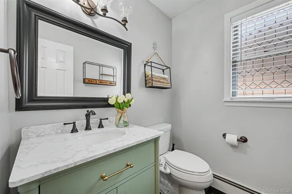 a bathroom with a granite countertop sink mirror and toilet