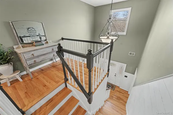 a view of a livingroom with wooden floor and stairs