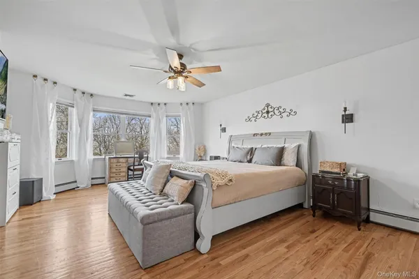 a bedroom with a bed couch and a large window