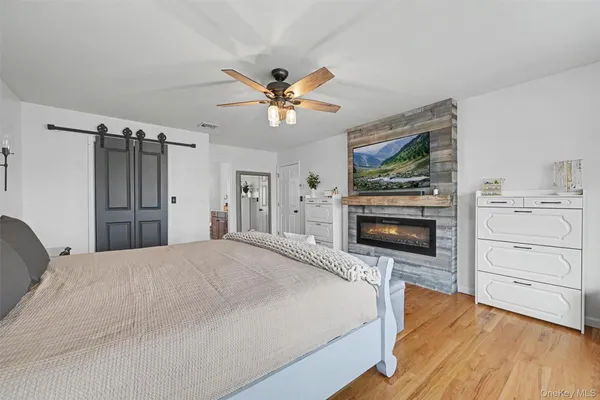 a spacious bedroom with a bed and a flat screen tv