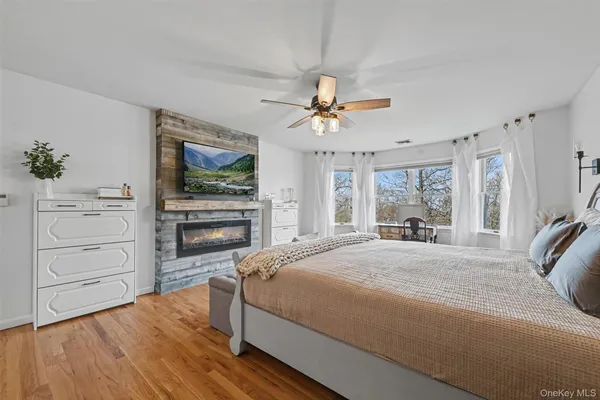 a bedroom with a bed a dresser and flat screen tv