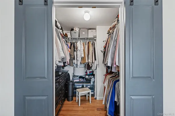 a view of walk in closet with clothes and shoes