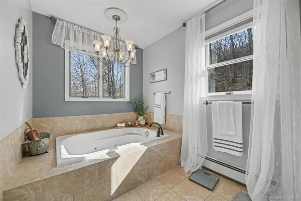 a spacious bathroom with a granite countertop tub and a chandelier