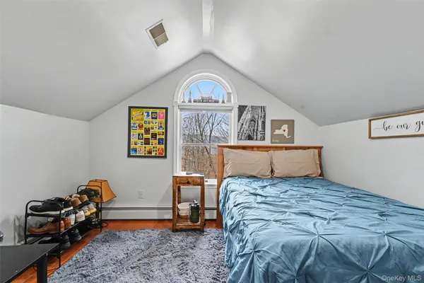 a bed sitting in a bedroom next to a window with desk and chair