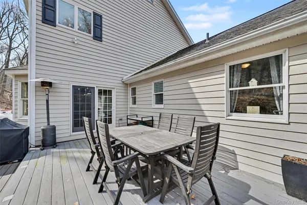 a view of a roof deck with table and chairs and wooden floor