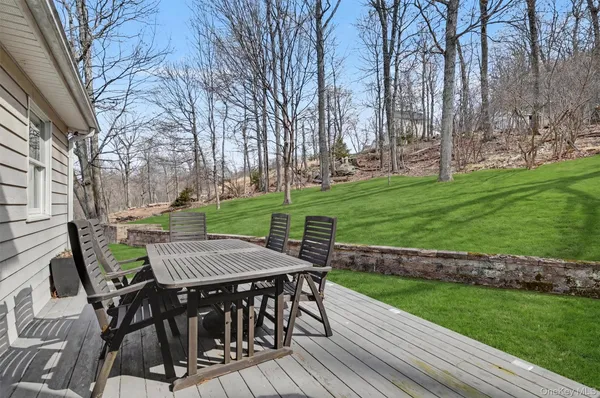 a view of a patio with table and chairs with wooden floor and fence