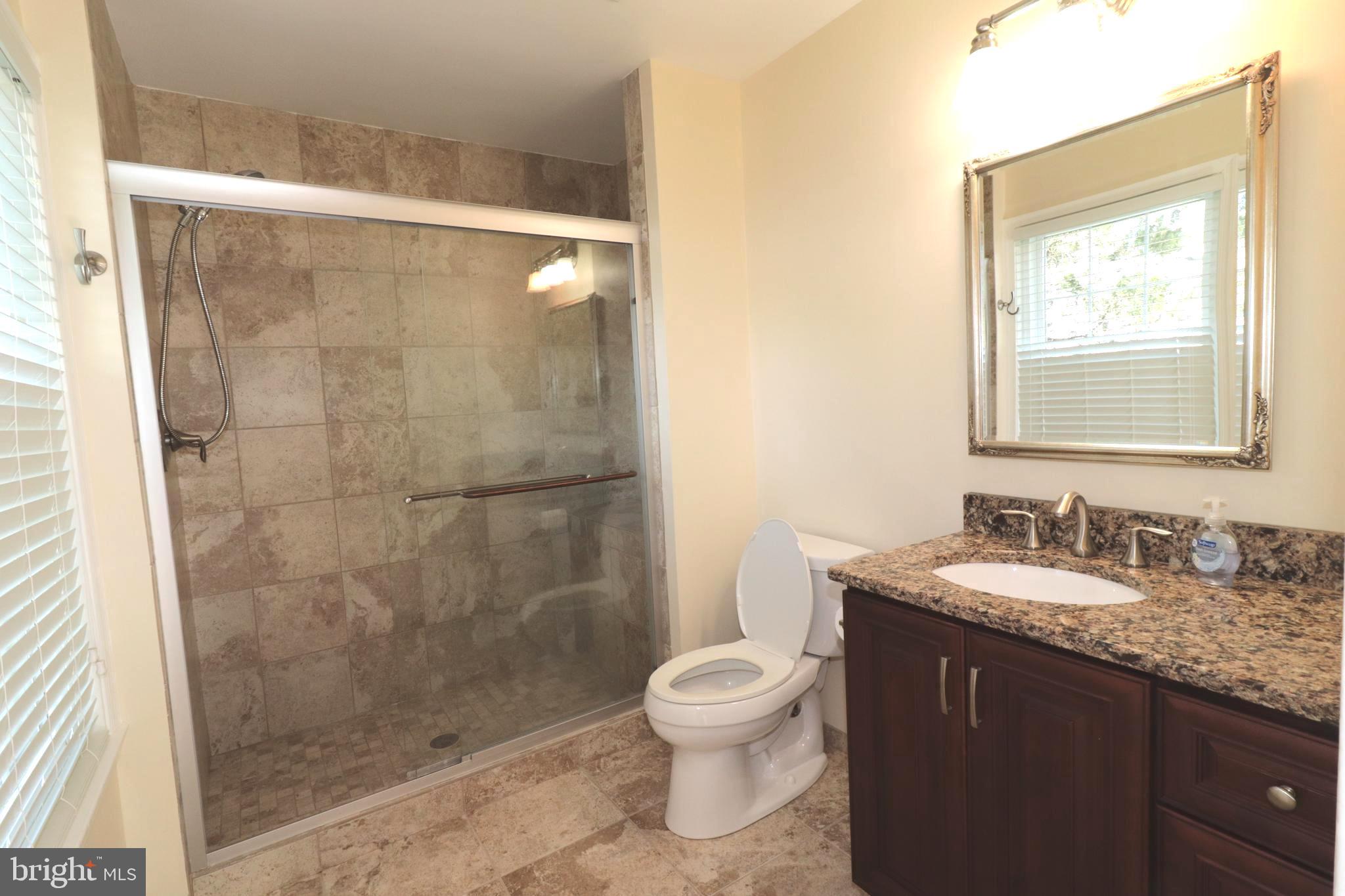 7907 Gambrill Court Springfield, VA 22153 - Photo 16 of 35 a bathroom with a granite countertop sink toilet and shower