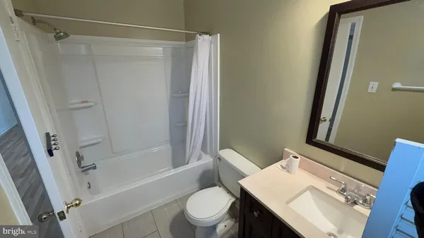 a bathroom with a sink a toilet a mirror and shower
