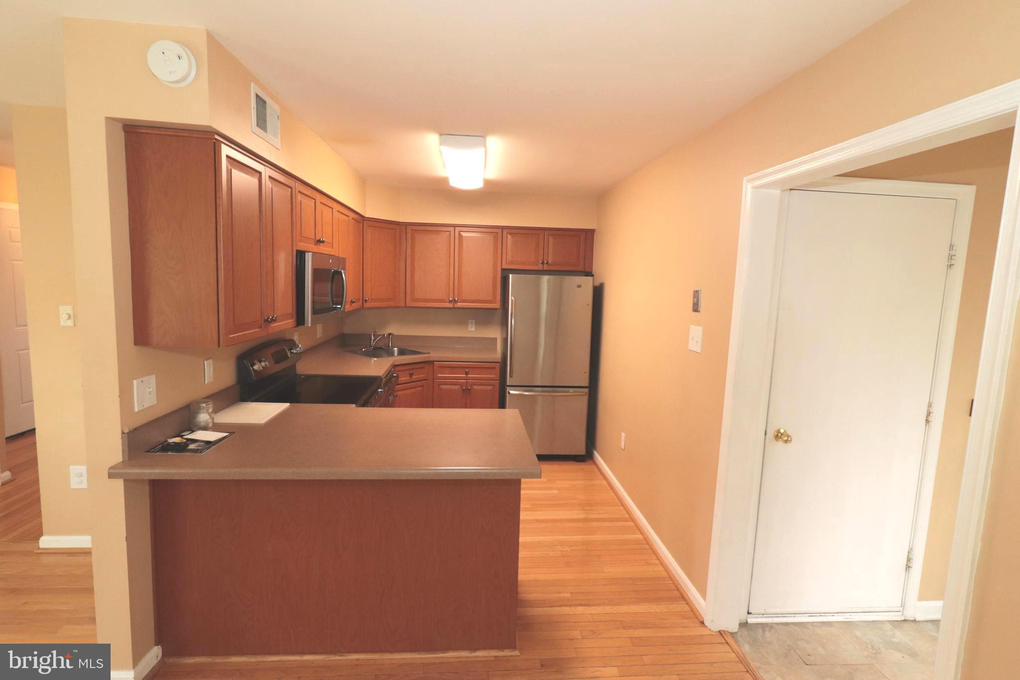 7907 Gambrill Court Springfield, VA 22153 - Photo 22 of 35 a kitchen with stainless steel appliances a refrigerator and a stove
