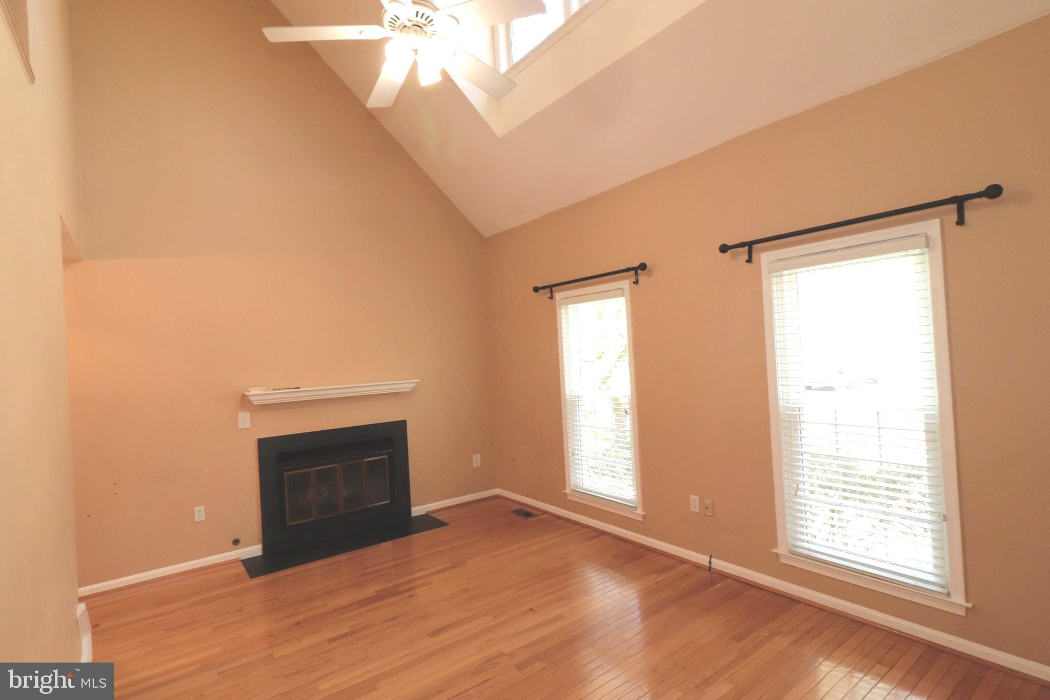 7907 Gambrill Court Springfield, VA 22153 - Photo 7 of 35 an empty room with a fireplace and windows