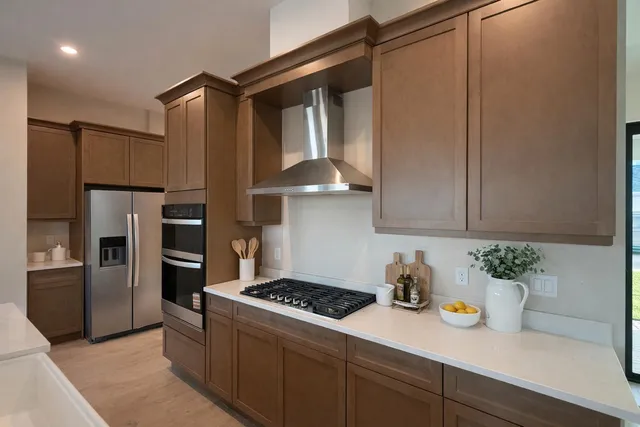 a kitchen with stainless steel appliances granite countertop a refrigerator and a stove
