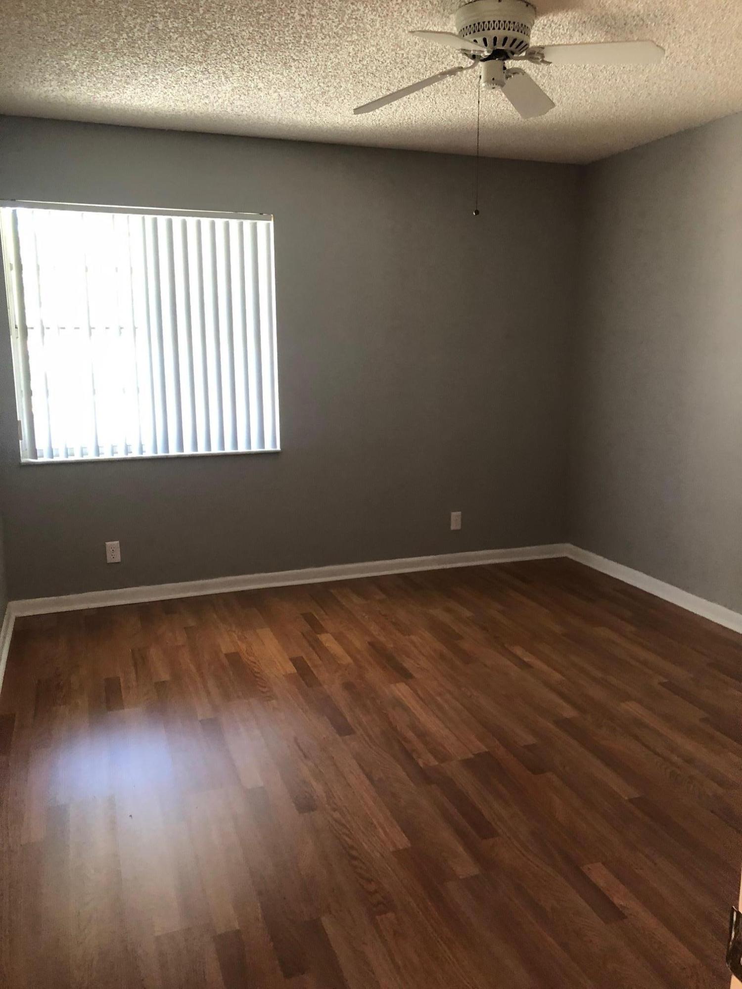 369 Normandy Lane Delray Beach, FL 33484 - Photo 8 of 14 en empty room with wooden floor and windows