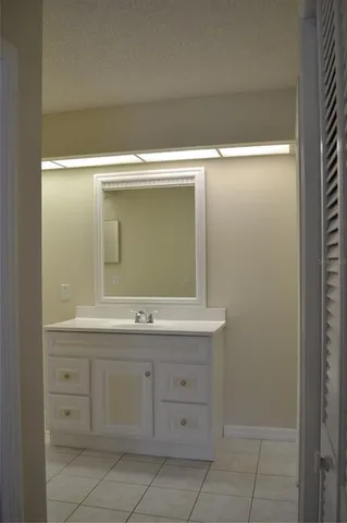 a bathroom with a granite countertop sink and a toilet