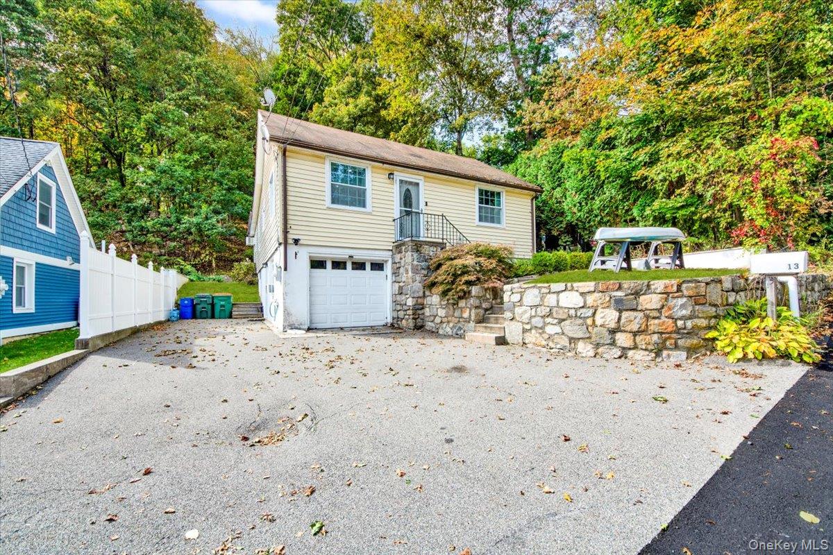 View of front of home featuring an attached garage, asphalt driveway, a gazebo, and a patio area