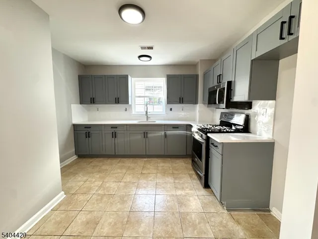 a kitchen with stainless steel appliances granite countertop a sink and cabinets