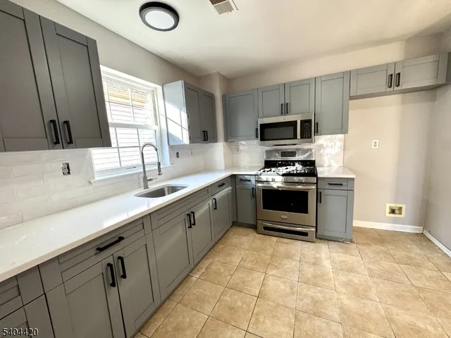 a kitchen with granite countertop a refrigerator and a sink