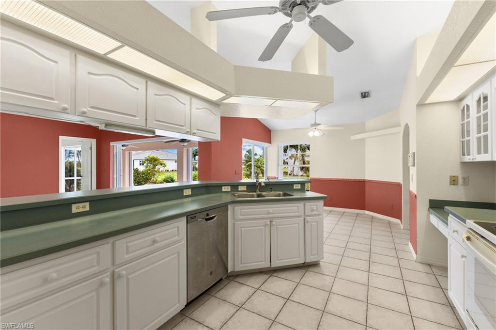 24060 Pyramid Way Punta Gorda, FL 33955 - Photo 13 of 48 Kitchen featuring light tile patterned floors, dishwasher, ceiling fan, sink, and white cabinetry