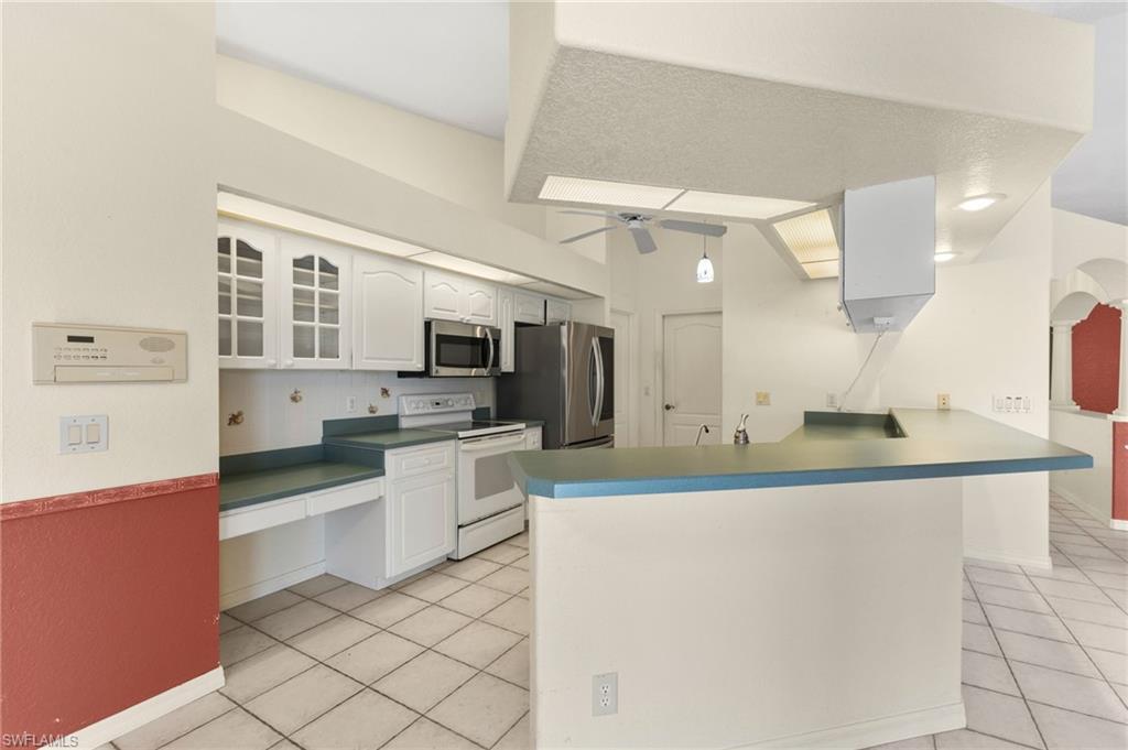 24060 Pyramid Way Punta Gorda, FL 33955 - Photo 15 of 48 Kitchen with ceiling fan, light tile patterned flooring, stainless steel appliances, and kitchen peninsula