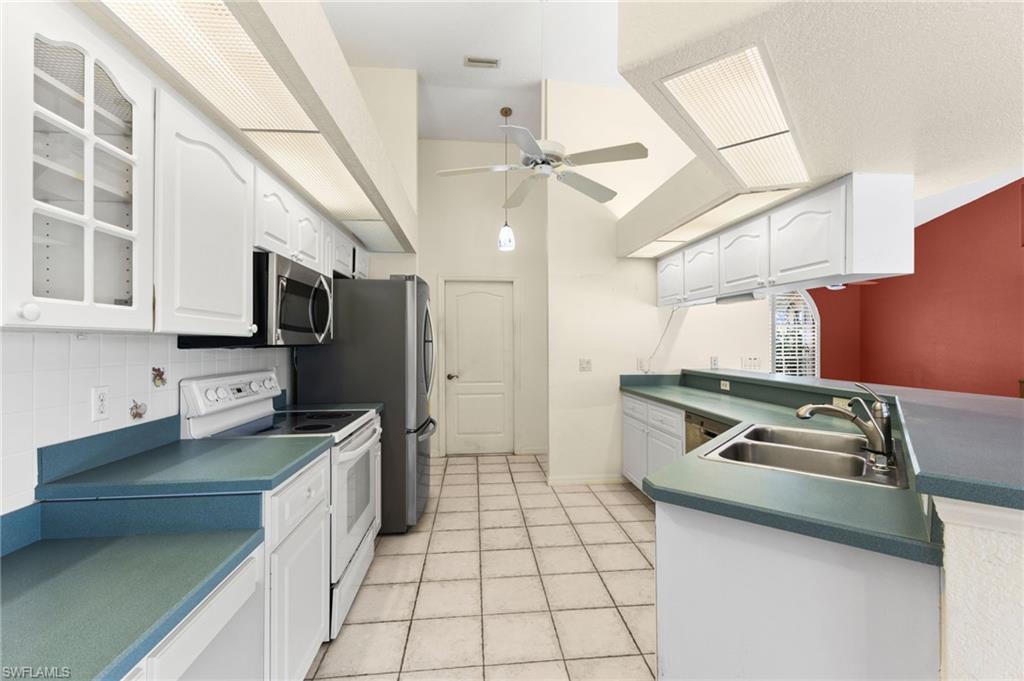 24060 Pyramid Way Punta Gorda, FL 33955 - Photo 16 of 48 Kitchen featuring ceiling fan, appliances with stainless steel finishes, light tile patterned floors, backsplash, and sink