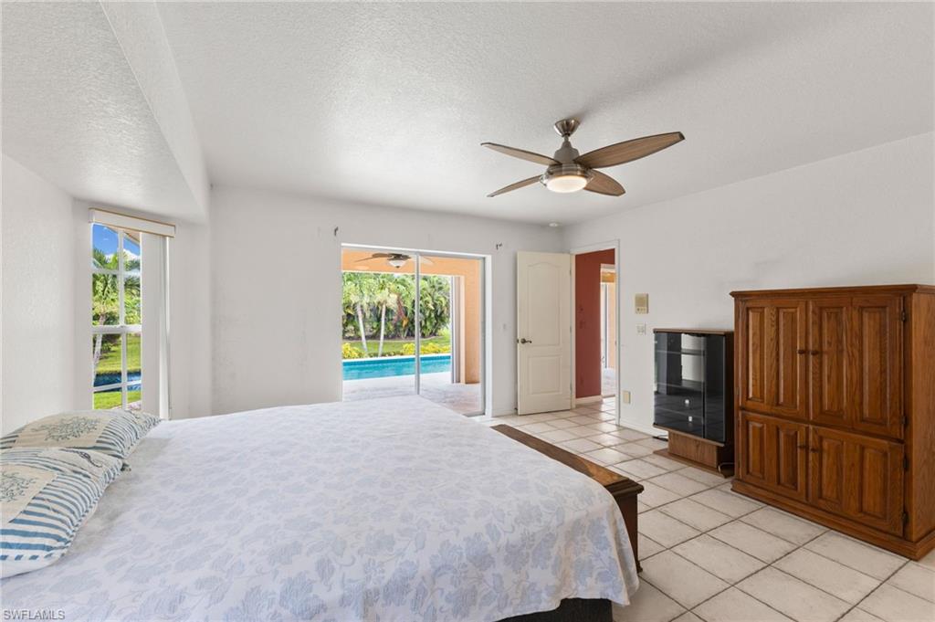 24060 Pyramid Way Punta Gorda, FL 33955 - Photo 19 of 48 Primary Bedroom featuring access to outside, light tile patterned flooring, ceiling fan, and multiple windows