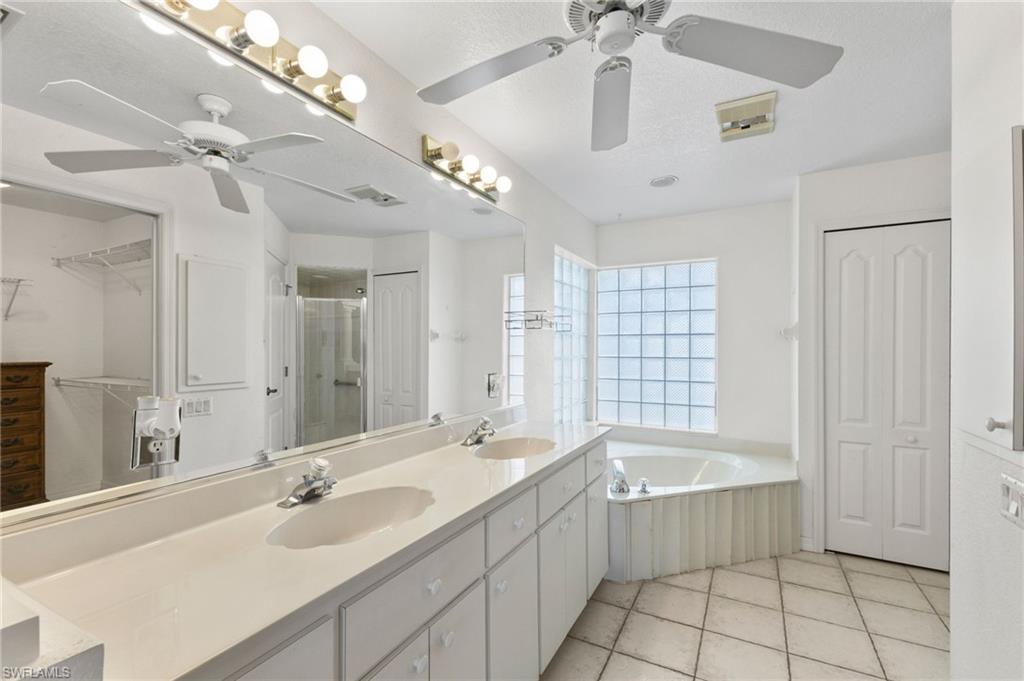 24060 Pyramid Way Punta Gorda, FL 33955 - Photo 21 of 48 Bathroom featuring double sink vanity, tile patterned flooring, ceiling fan, and separate shower and tub