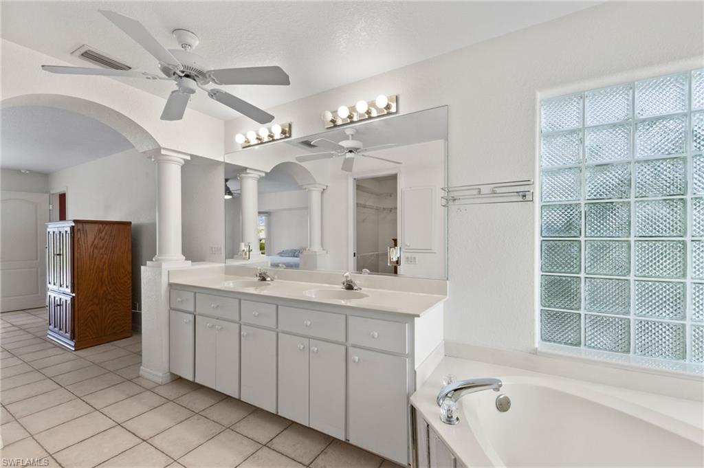 24060 Pyramid Way Punta Gorda, FL 33955 - Photo 23 of 48 Bathroom featuring decorative columns, ceiling fan, plenty of natural light, tile patterned flooring, and a tub to relax in