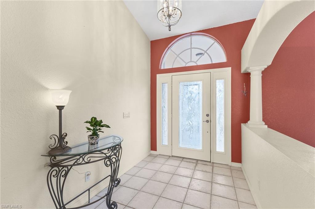 24060 Pyramid Way Punta Gorda, FL 33955 - Photo 4 of 48 Foyer entrance with light tile patterned floors, a notable chandelier, ornate columns, and plenty of natural light