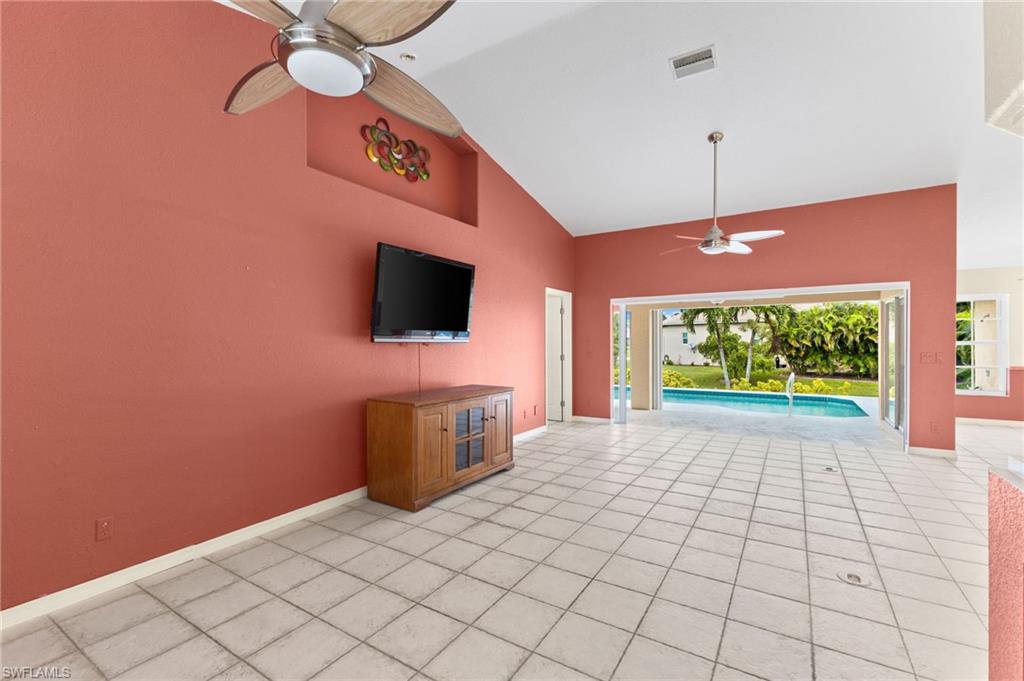 24060 Pyramid Way Punta Gorda, FL 33955 - Photo 8 of 48 Unfurnished living room featuring ceiling fan, high vaulted ceiling, and light tile patterned floors