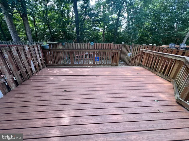 a view of deck with wooden fence and trees