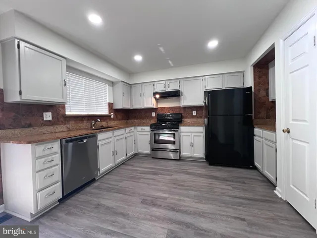 a kitchen with granite countertop cabinets stainless steel appliances and a sink