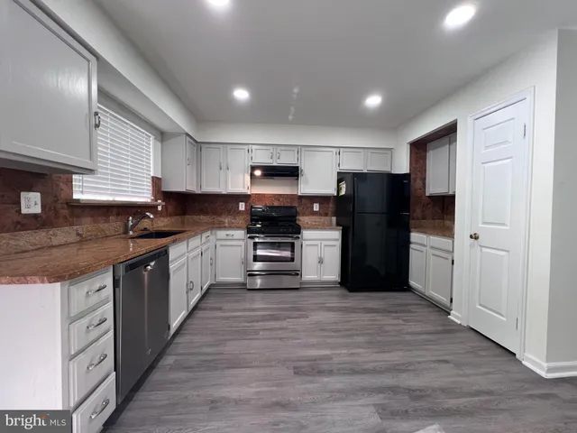 a kitchen with a refrigerator stove and white cabinets