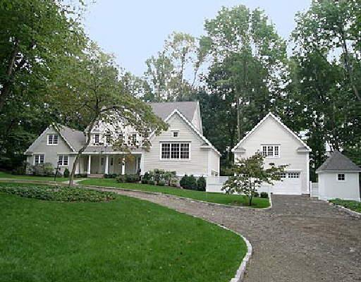 a front view of a house with a garden and trees
