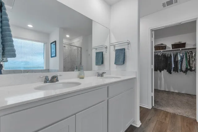 a bathroom with a double vanity sink and mirror