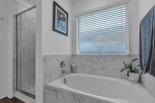 a white bath tub sitting next to a shower