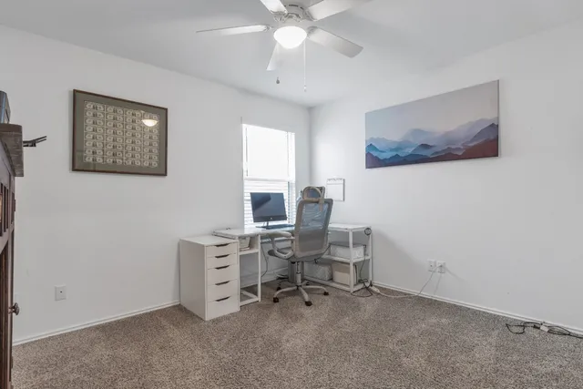 a view of a workspace with furniture and a window
