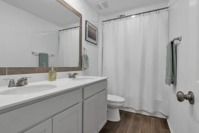 a bathroom with a granite countertop sink toilet and a mirror