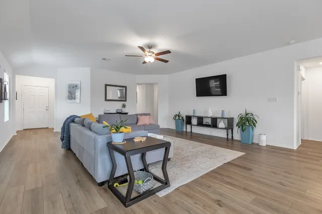 a living room with furniture a wooden floor and a flat screen tv