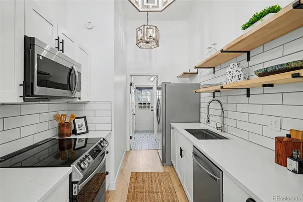 a kitchen with a refrigerator and a stove top oven