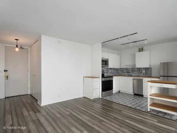 a view of a kitchen with furniture and wooden floor