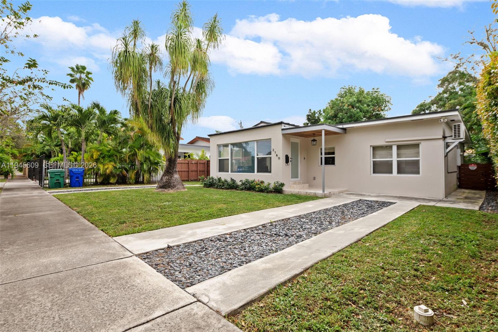 2180 Southwest 20th Street Miami, FL 33145 - Photo 2 of 25 a front view of a house with a yard and trees