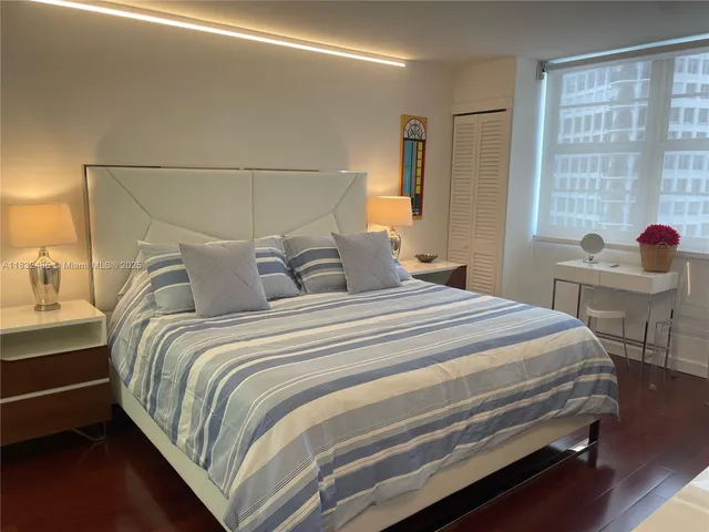 a bedroom with a bed and large windows