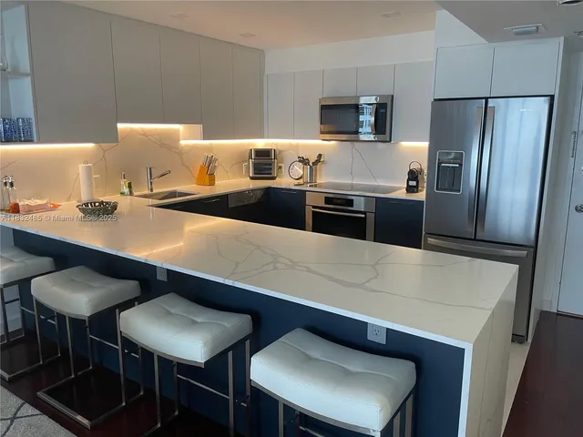 a kitchen with stainless steel appliances a sink and a refrigerator