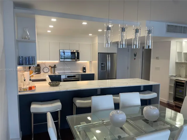 a kitchen with stainless steel appliances granite countertop a sink and a refrigerator