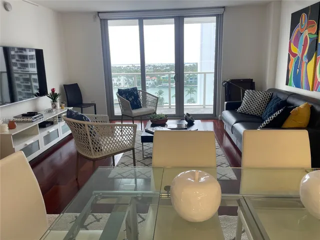 a living room with furniture and a floor to ceiling window