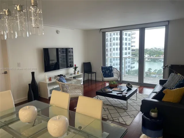 a living room with furniture and a floor to ceiling window