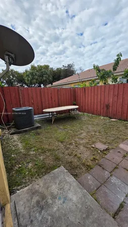 a view of a backyard with wooden fence