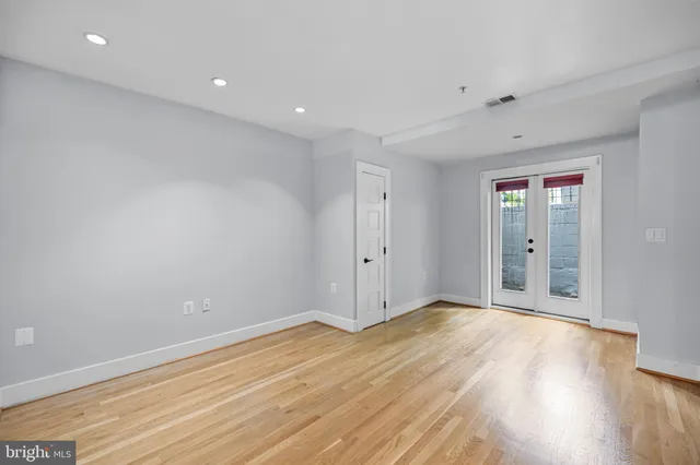 a view of an empty room with wooden floor