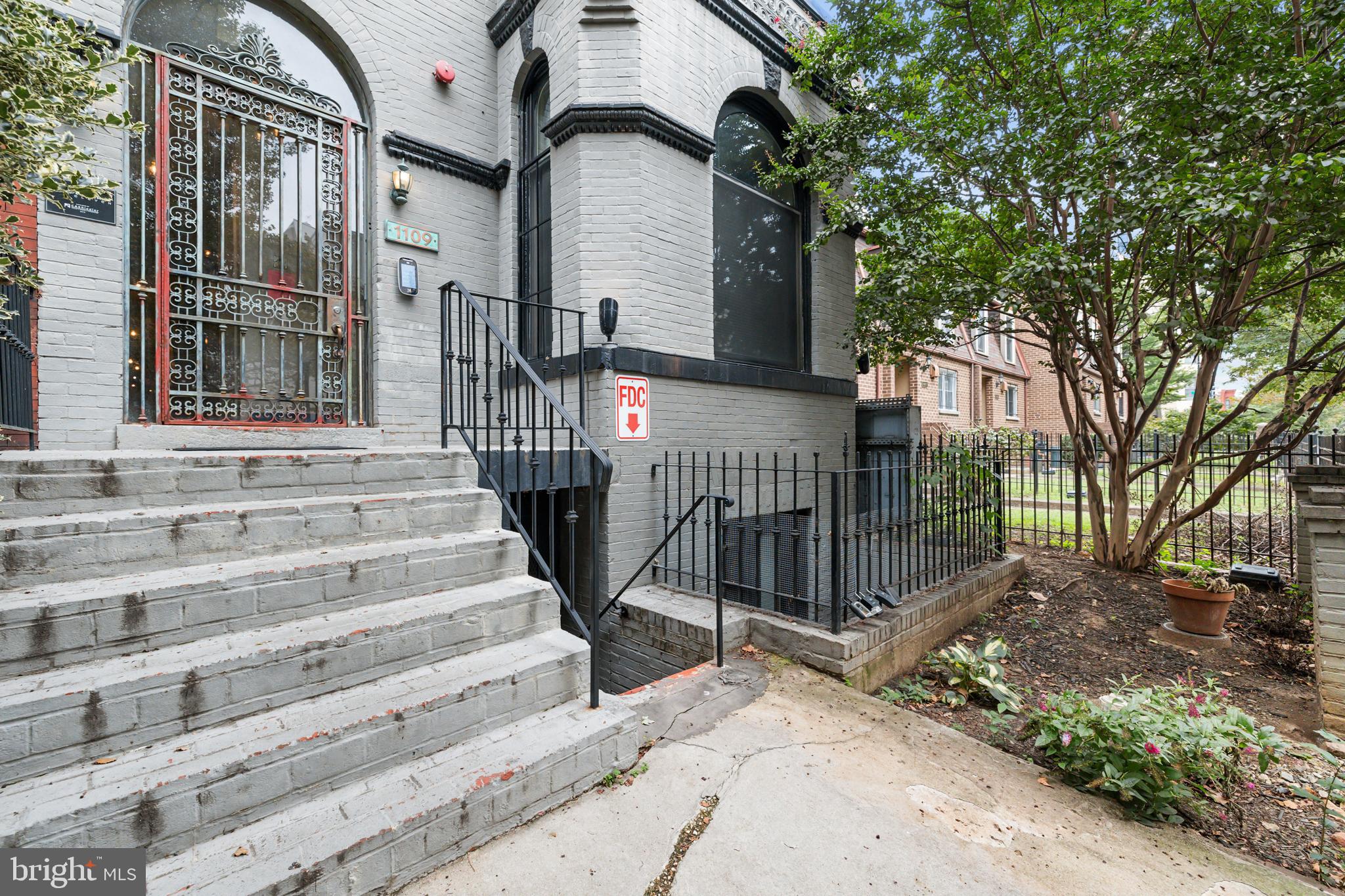 1109 M Street Northwest, Unit 1 Washington, DC 20005 - Photo 2 of 32 a view of house with wooden fence and large trees