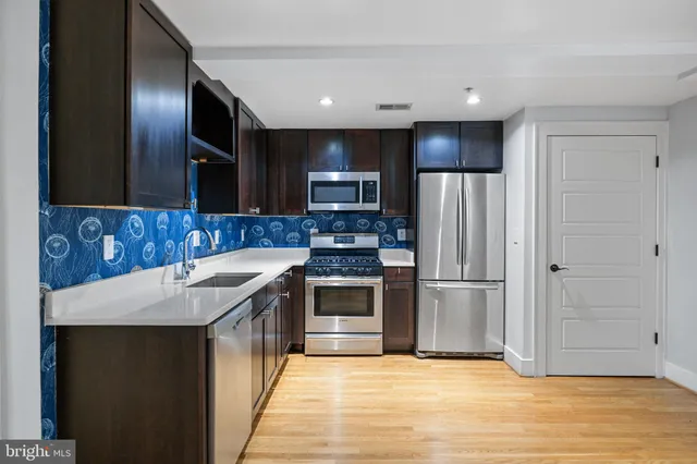 a kitchen with kitchen island granite countertop a stove and a refrigerator