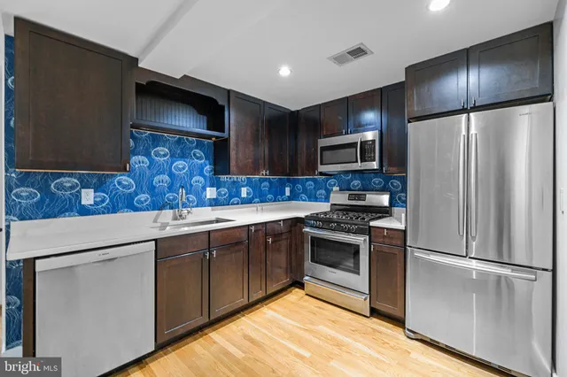 a kitchen with stainless steel appliances granite countertop a refrigerator stove and sink